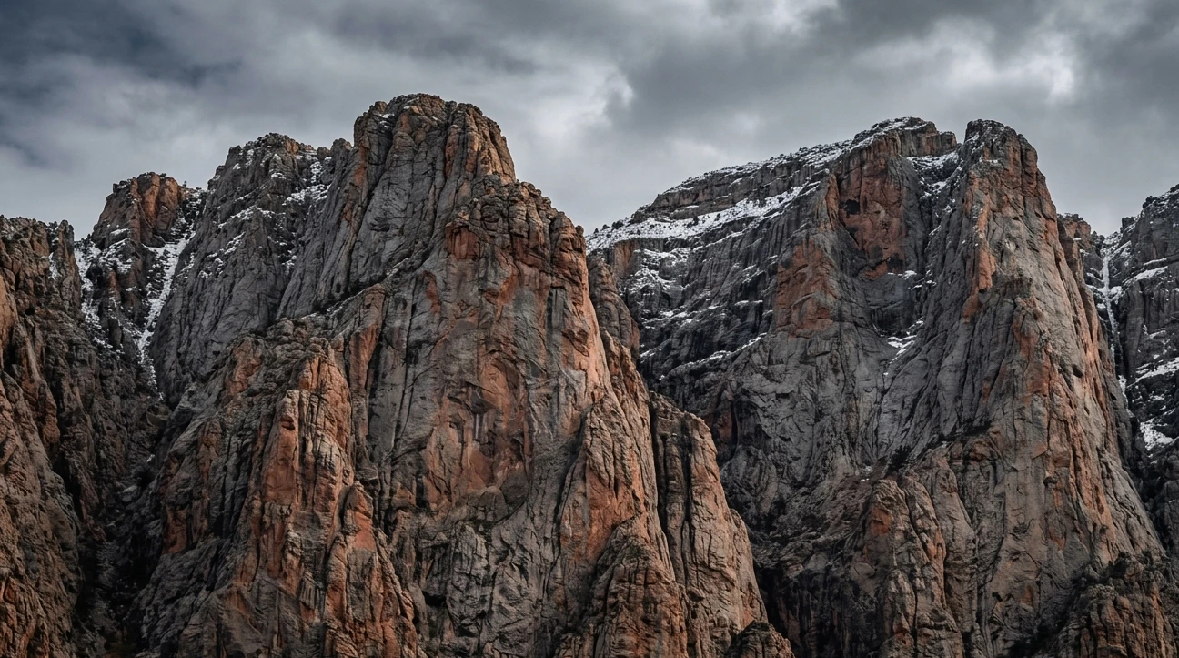 Rugged mountain peaks under a dramatic stormy sky